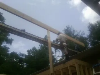 Carpenter setting a ridge beam over a new addition frame — Ice Dam Removal by Roofing Brothers in East Islip
