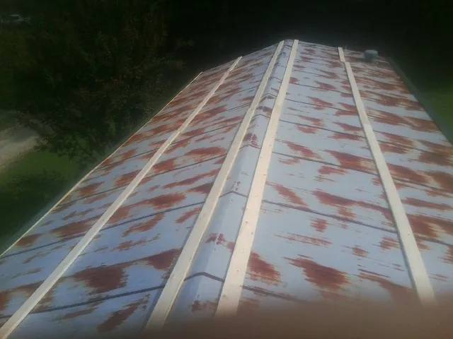 Rusted metal roof panels with new wood purlins before replacement — Storm Damage Roof Repair in East Islip by Roofing Brothers
