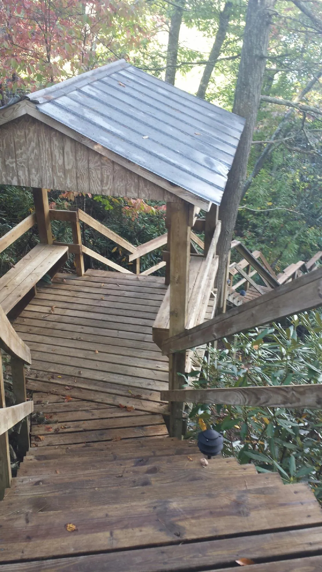 Metal roofed shelter over wooden steps on a wooded walkway — Skylight Repair & Installation work by our crew in East Islip