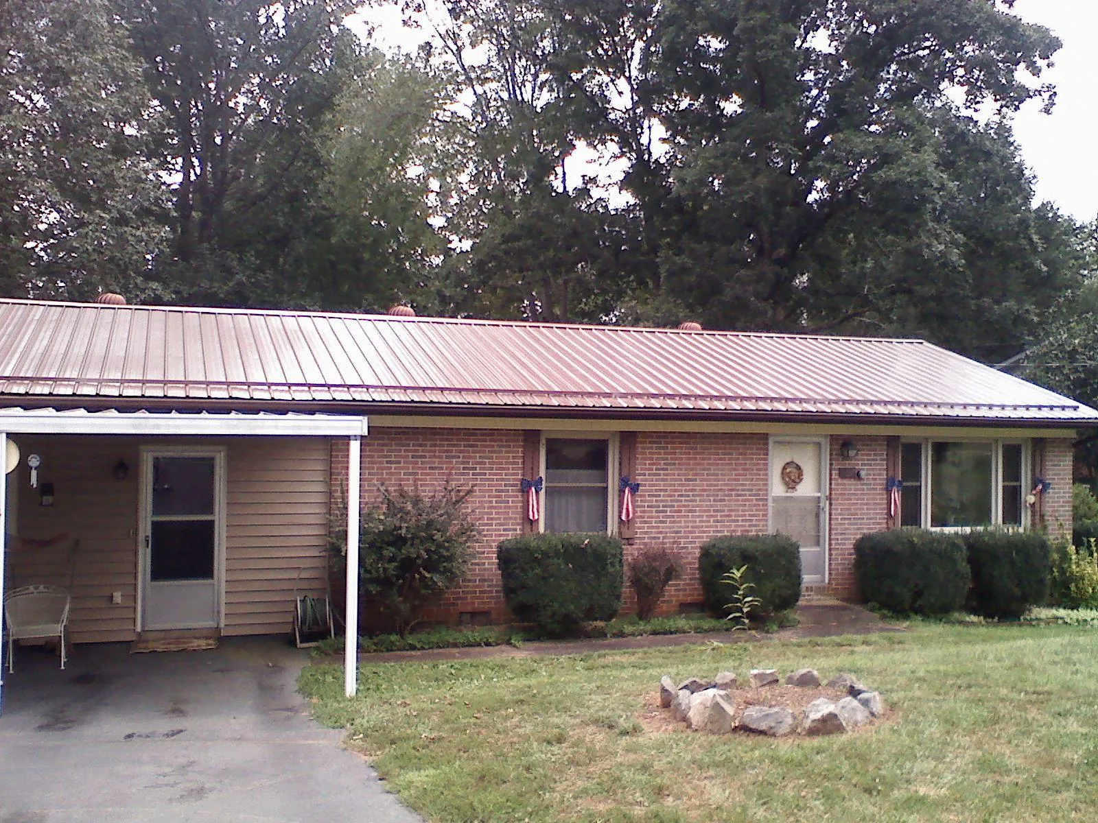 Bronze metal roof and carport on a brick ranch home — Roof Repair work by our crew in East Islip